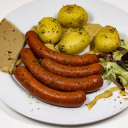 Recette classique de salade de saucisse bavaroise avec des pommes de terre rôties copieuses et une vinaigrette au moutarde épicée