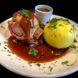 Piernas de cerdo crujientes con glaseado de cerveza y knödel de pan.